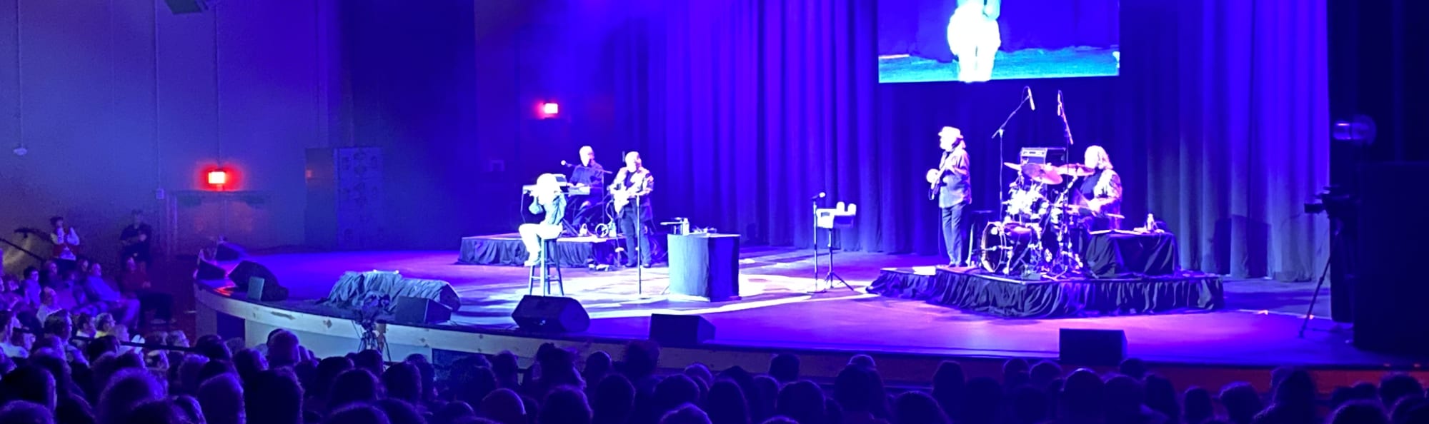 signer on stage in chair washed out by the lights Charlottesville